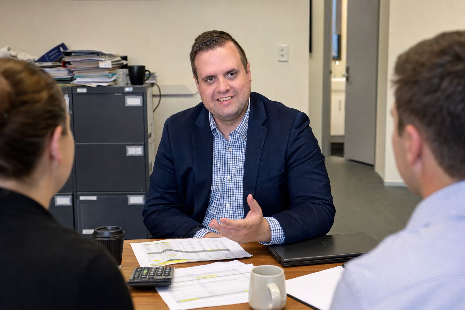 Brandon from Defy IT sitting down with two accountants over printed reconciliations and a calculator