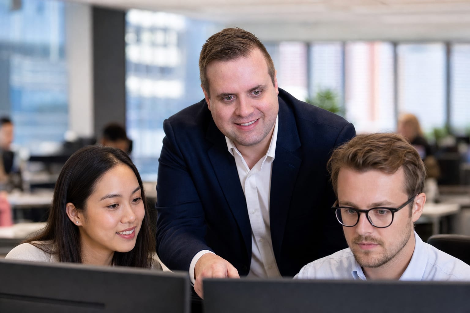 Brandon from Defy IT working with two staff members in a modern office