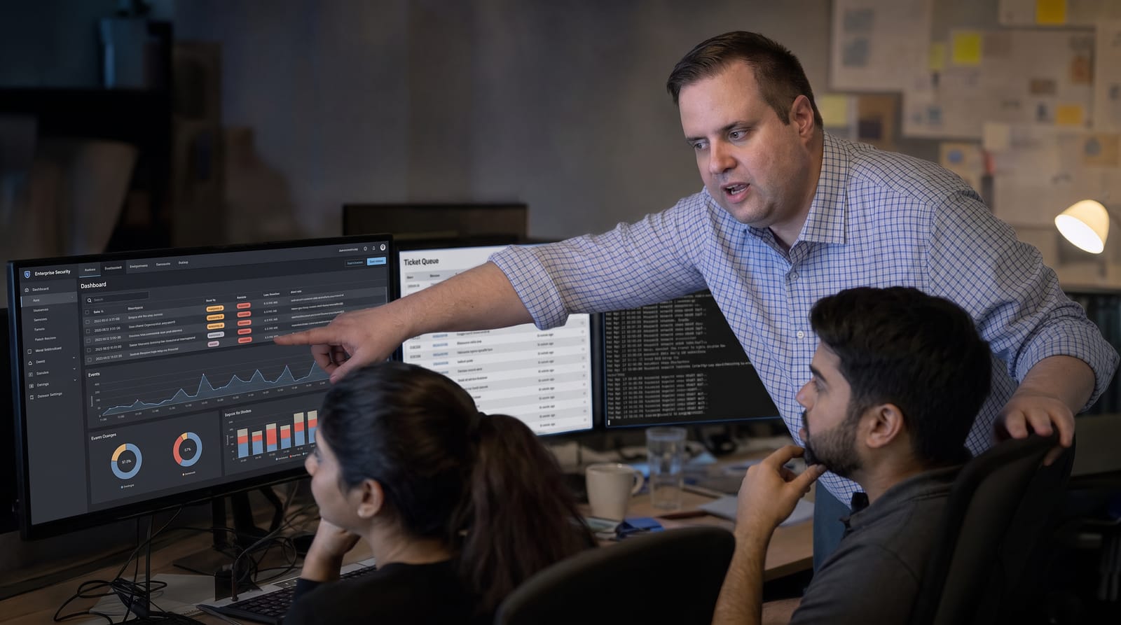 Brandon from Defy IT walking two colleagues through a security dashboard of alerts and events