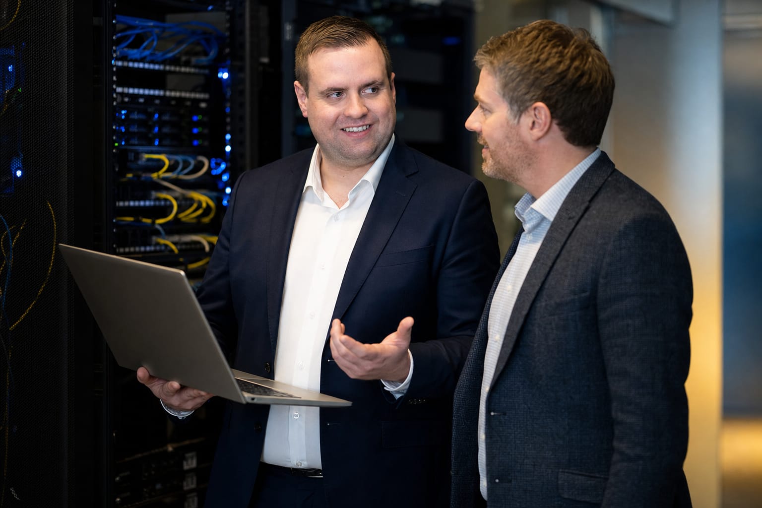 Brandon from Defy IT reviewing server infrastructure on a laptop with a client in a data centre